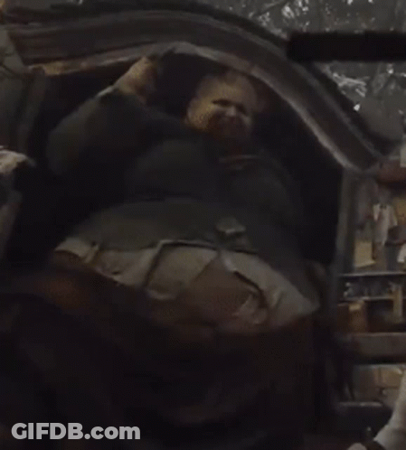 A Man With A Beard Is Laying Down In A Chair GIF
