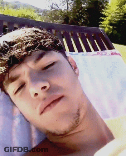 A Man With A Beard Is Laying In A Chair With His Eyes Closed GIF