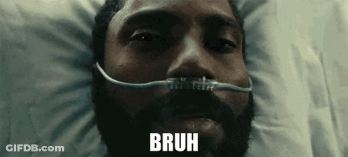A Man With A Beard Is Laying In A Hospital Bed With An Oxygen Mask On His Face And The Word Bruh Above Him . GIF