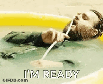 A Man With A Beard Is Laying In A Pool Of Water Drinking Water Through A Straw . GIF