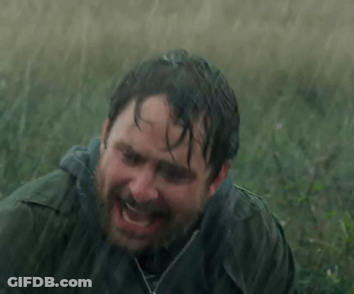 A Man With A Beard Is Laying In The Rain With His Eyes Closed GIF