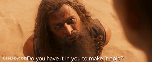 A Man With A Beard Is Laying In The Sand With The Words Do You Have It In You To Make It Epic GIF