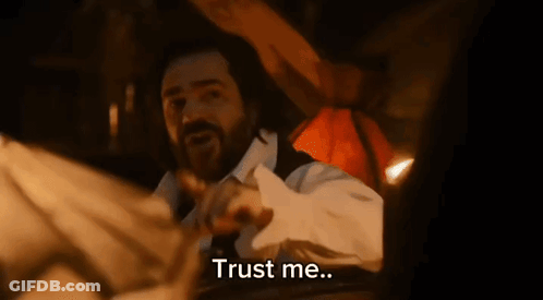 A Man With A Beard Is Laying On A Bed With The Words Trust Me Written Below Him GIF