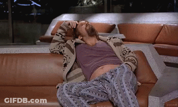 A Man With A Beard Is Laying On A Couch . GIF