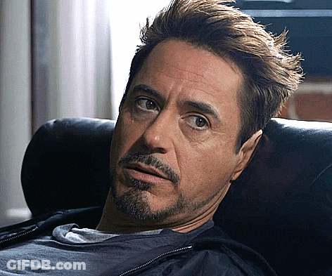 A Man With A Beard Is Laying On A Couch Looking At The Camera GIF