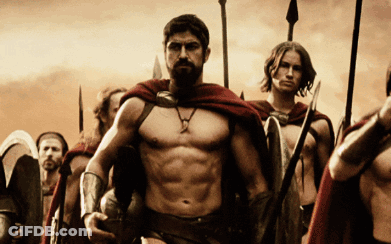 A Man With A Beard Is Leading A Group Of Men With Spears And Shields GIF