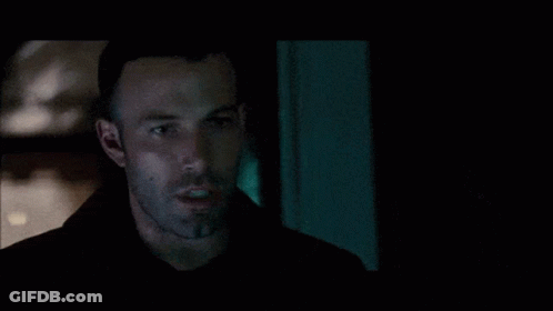 A Man With A Beard Is Looking At Something In The Dark GIF