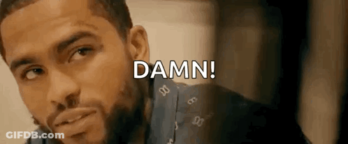 A Man With A Beard Is Looking At The Camera And The Words `` Damn '' Are Written Above Him . GIF