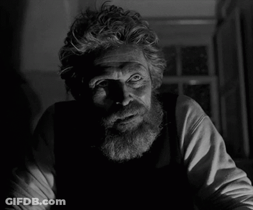 A Man With A Beard Is Looking At The Camera In A Black And White Photo GIF