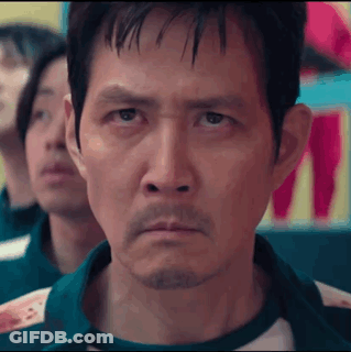 A Man With A Beard Is Looking At The Camera While Playing A Game . GIF