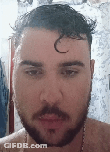 A Man With A Beard Is Looking At The Camera With A C On His Forehead GIF