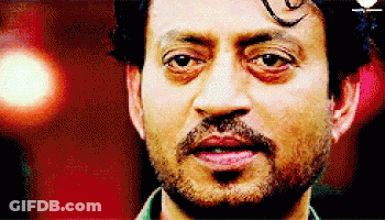 A Man With A Beard Is Looking At The Camera With A Red Background GIF
