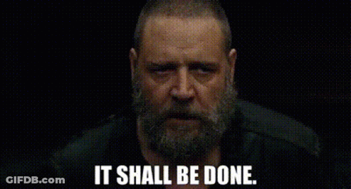 A Man With A Beard Is Looking At The Camera With The Words `` It Shall Be Done '' Written Below Him . GIF