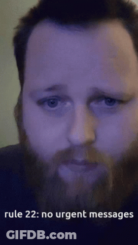 A Man With A Beard Is Looking At The Camera With The Words Rule 22 : No Urgent Messages Below Him GIF