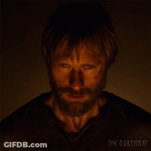 A Man With A Beard Is Looking At The Camera With The Words The Northman Behind Him GIF