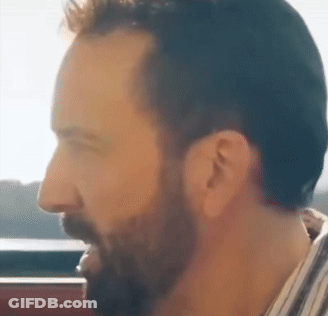 A Man With A Beard Is Looking Out A Window GIF