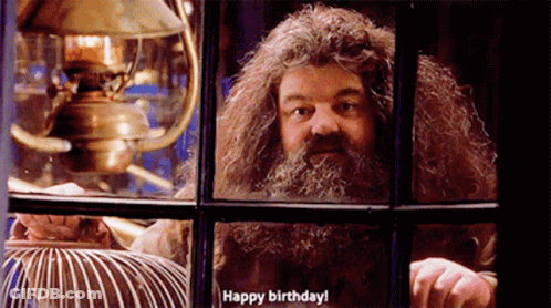 A Man With A Beard Is Looking Out Of A Window And Saying Happy Birthday GIF