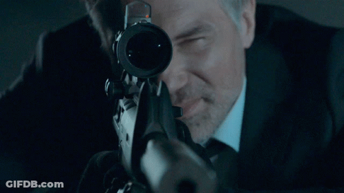 A Man With A Beard Is Looking Through A Scope GIF