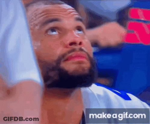 A Man With A Beard Is Looking Up At The Sky While Sitting In A Stadium . GIF