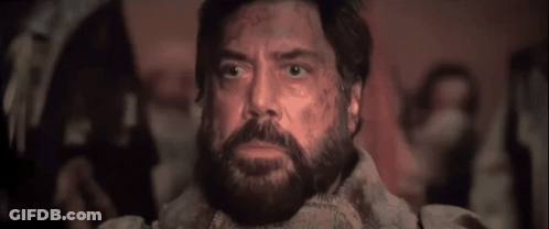 A Man With A Beard Is Looking Up In A Dark Room GIF