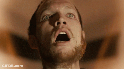 A Man With A Beard Is Looking Up With His Mouth Wide Open GIF