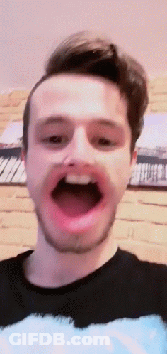 A Man With A Beard Is Making A Face With His Mouth Open . GIF