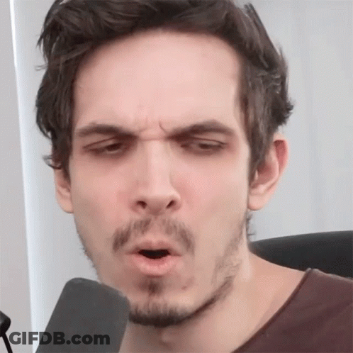 A Man With A Beard Is Making A Face With His Mouth Open GIF