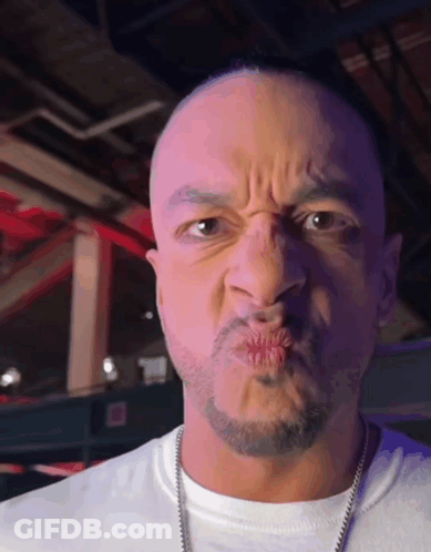 A Man With A Beard Is Making A Face With His Mouth Open GIF