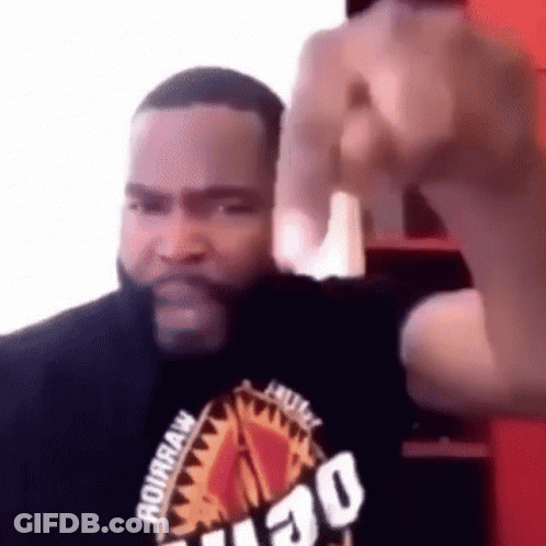 A Man With A Beard Is Making A Funny Face And Giving The Middle Finger . GIF
