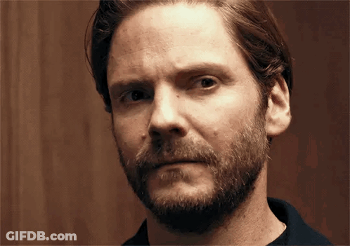 A Man With A Beard Is Making A Funny Face And Looking At The Camera . GIF