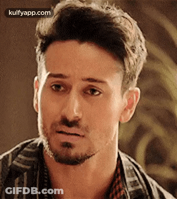 A Man With A Beard Is Making A Funny Face And Looking At The Camera . GIF
