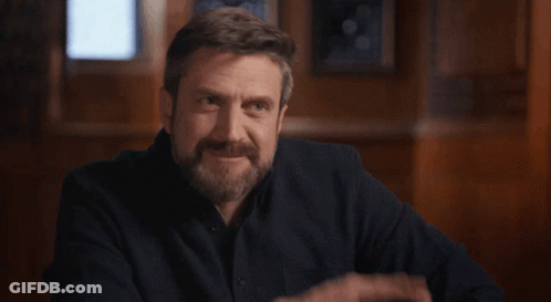 A Man With A Beard Is Making A Funny Face And Pointing GIF