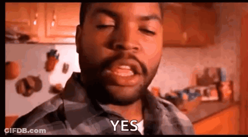 A Man With A Beard Is Making A Funny Face And Saying Yes In A Kitchen . GIF