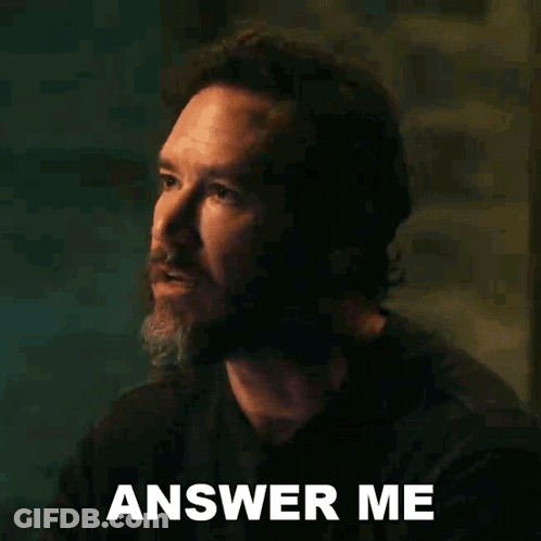 A Man With A Beard Is Making A Funny Face And Says Answer Me . GIF