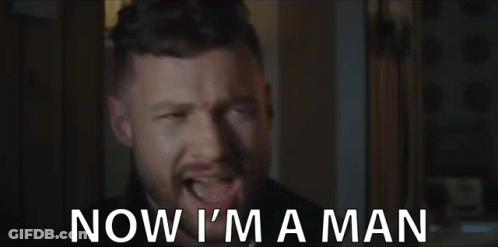 A Man With A Beard Is Making A Funny Face And Says `` Now I 'M A Man '' . GIF