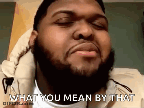 A Man With A Beard Is Making A Funny Face And Says What You Mean By That GIF