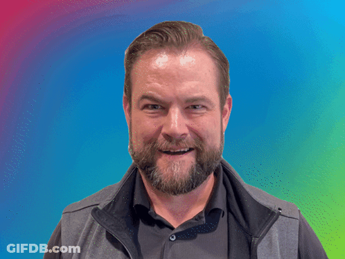 A Man With A Beard Is Making A Funny Face In Front Of A Banner That Says Brilliant GIF