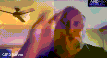 A Man With A Beard Is Making A Funny Face In Front Of A Ceiling Fan . GIF