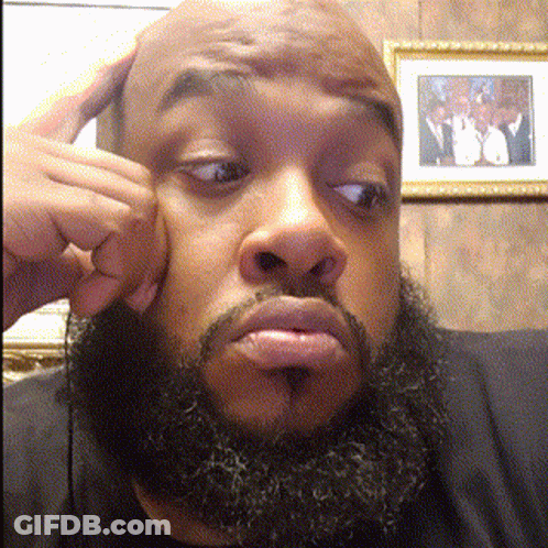 A Man With A Beard Is Making A Funny Face In Front Of A Framed Picture GIF