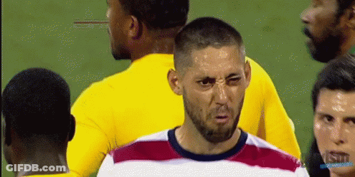 A Man With A Beard Is Making A Funny Face In Front Of A Group Of Soccer Players GIF