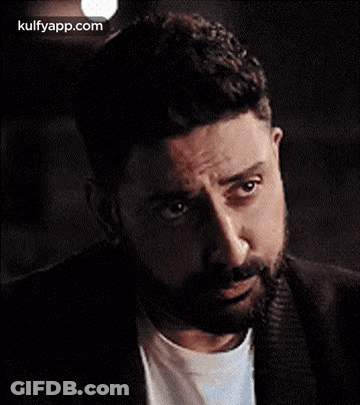 A Man With A Beard Is Making A Funny Face While Looking At The Camera . GIF