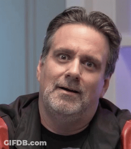 A Man With A Beard Is Making A Funny Face While Looking At The Camera . GIF