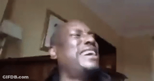 A Man With A Beard Is Making A Funny Face While Sitting In A Living Room . GIF