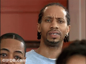 A Man With A Beard Is Making A Funny Face While Standing In A Crowd . GIF