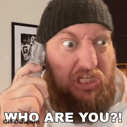 A Man With A Beard Is Making A Funny Face While Talking On A Cell Phone And Says Who Are You ? GIF