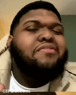 A Man With A Beard Is Making A Funny Face With His Eyes Closed And His Mouth Open . GIF