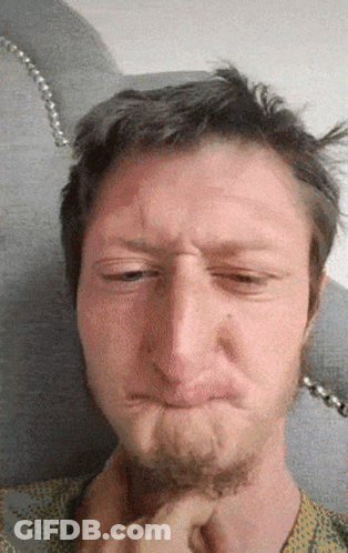 A Man With A Beard Is Making A Funny Face With His Eyes Closed GIF