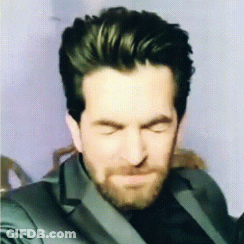 A Man With A Beard Is Making A Funny Face With His Eyes Closed GIF