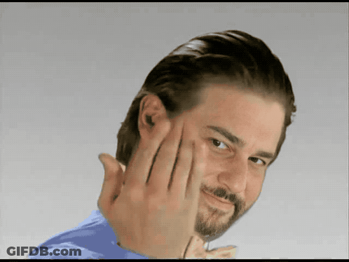 A Man With A Beard Is Making A Funny Face With His Hand GIF