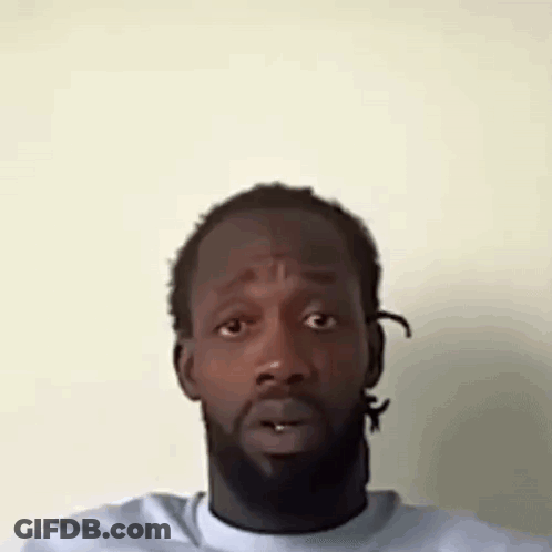 A Man With A Beard Is Making A Funny Face With His Mouth Open . GIF